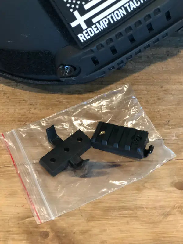 Black plastic gun parts in a clear bag for RT2 Ballistic High Cut Helmet by Redemption Tactical