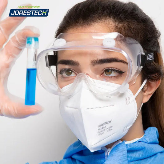 Scientist with blue liquid in test tube wearing anti-fog ventilated safety goggles