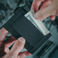 Black fabric wallet showcasing cash from Sergeant Wallet in Coyote Leather