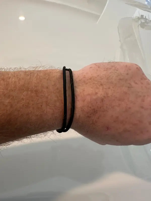 Simple black cord bracelet on wrist, ideal as a Breaklet - Emergency Escape Bracelet