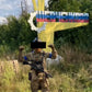 Soldier in camouflage body armor with assault rifle and medical kit in front of a sign