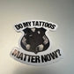 Sticker of tattooed police figure asking if tattoos matter for first responders