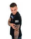 Black stigma-breaking unisex tee with American flag patch, showcasing tattooed arm