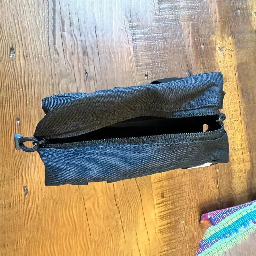 Black zippered pencil case with pull tab in Tactical Molle Bag for organizing gear