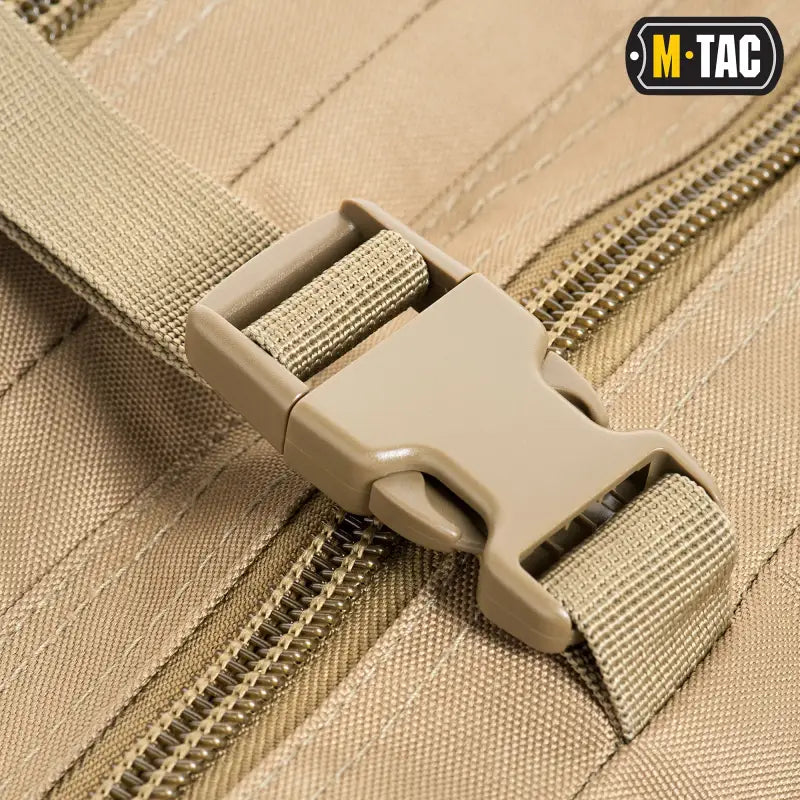 Tan plastic buckle fastener on nylon webbing for M-Tac Assault Pack’s large compartments