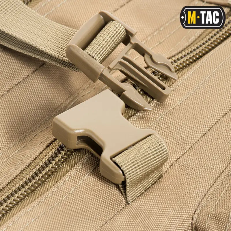 Tan plastic buckle fastener on beige webbing straps for M-Tac Assault Pack compartments