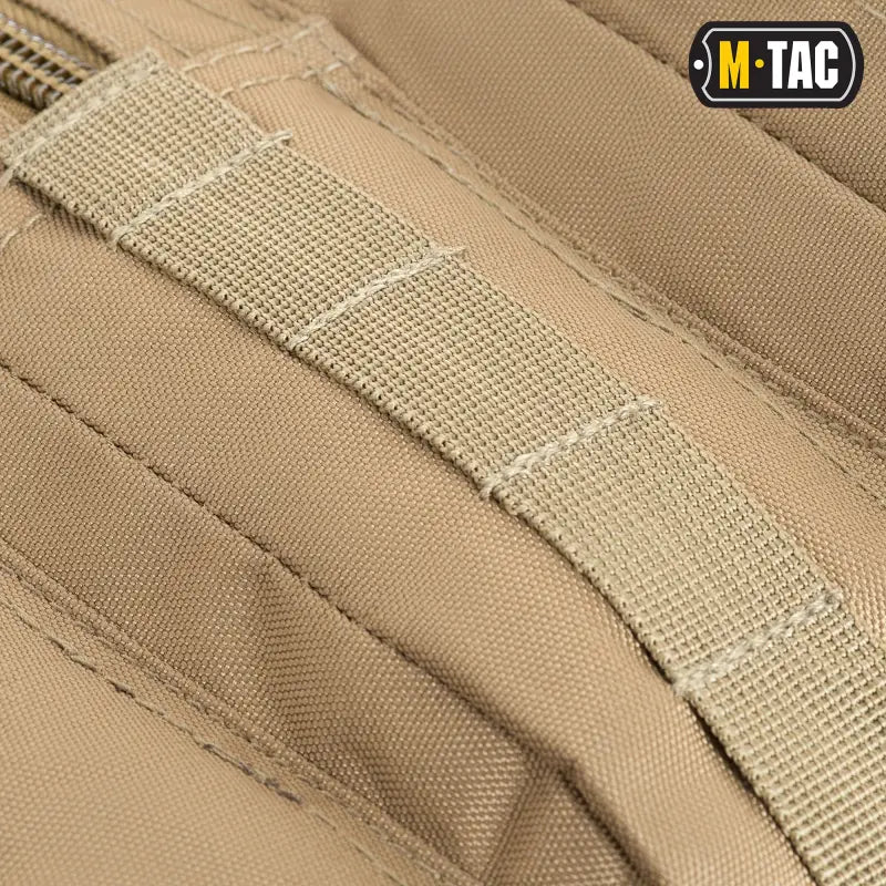 Tan tactical webbing strap with reinforced stitching on M-Tac Assault Pack