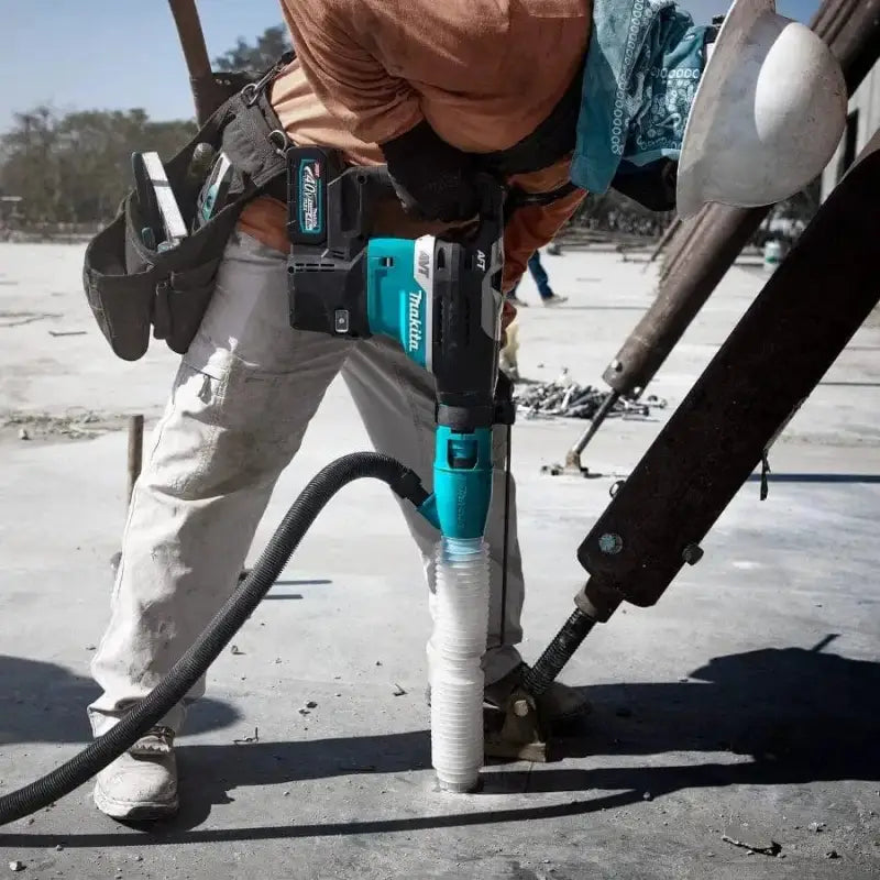 Teal Makita GRH05M1 XGT® Brushless AVT® Rotary Hammer drilling into concrete