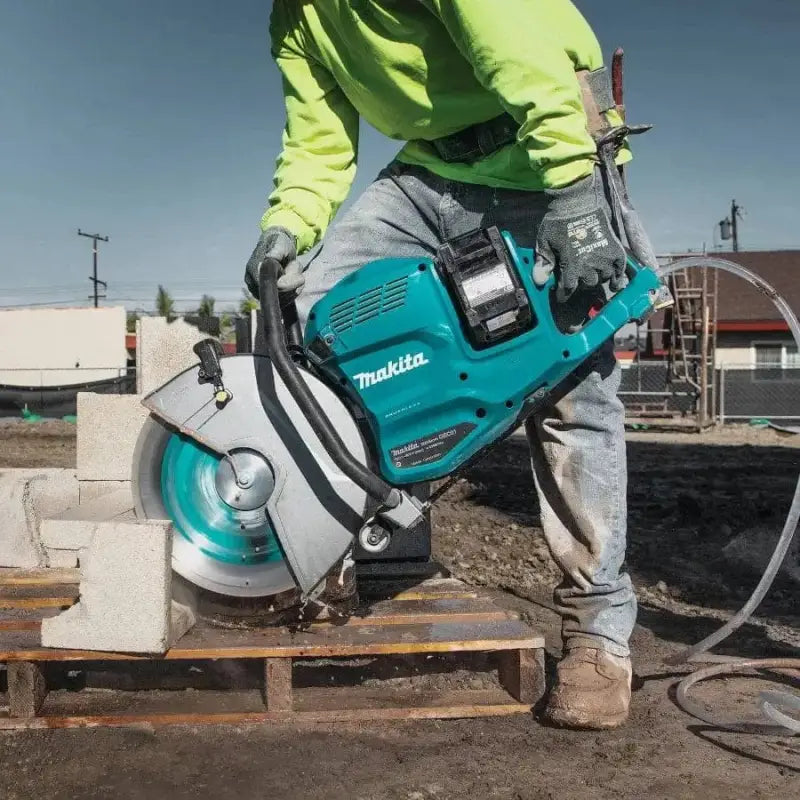 Teal Makita GEC01PL 80V XGT brushless power saw cutting through concrete masonry