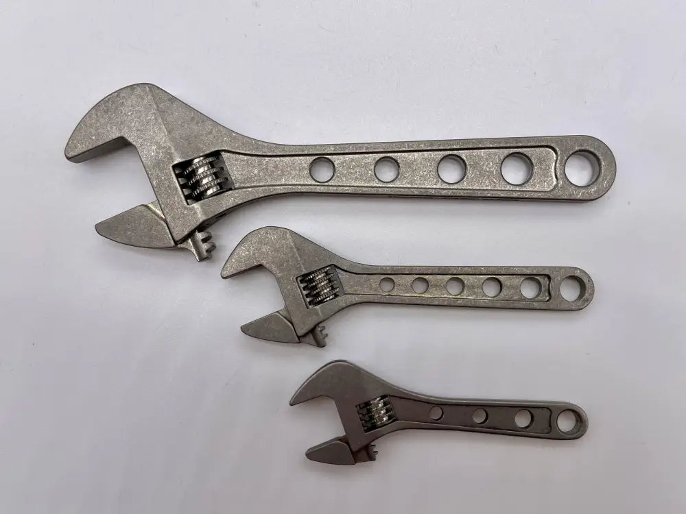 Three adjustable wrenches in descending size, featuring NSN pending titanium design