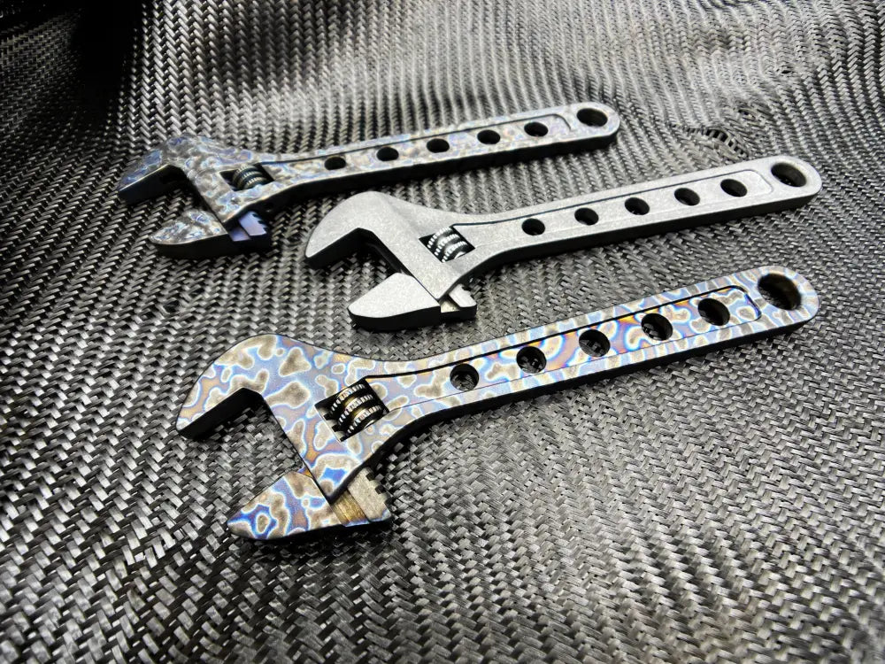 Three adjustable wrenches with decorative holes, featuring a Titanium Adjustable Wrench design