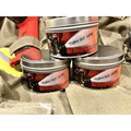 Three metal tins of Turn Out Gear labeled for the gear scented candle collection