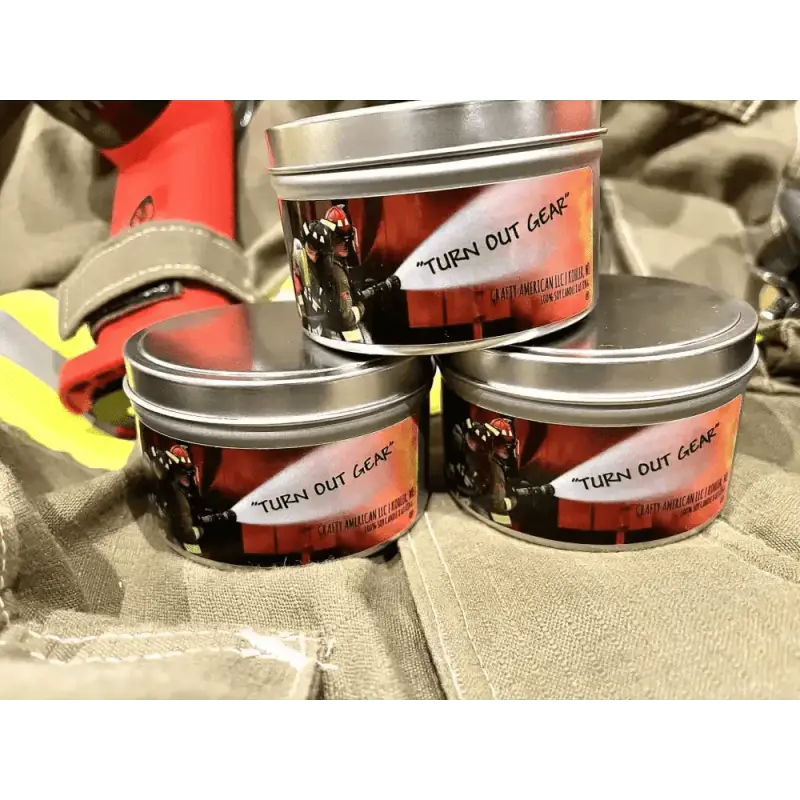 Three metal tins of Turn Out Gear labeled for the gear scented candle collection