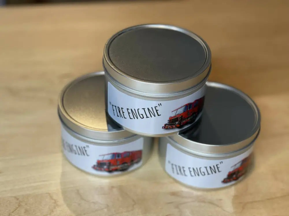 Three stacked metal tins labeled Fire Engine with red truck graphics for scented candle