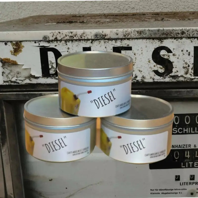 Three stacked silver tins labeled Diesel for a Diesel Scented Candle product