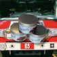 Three stacked tins of Fire Engine Scented Candle on a vibrant red surface