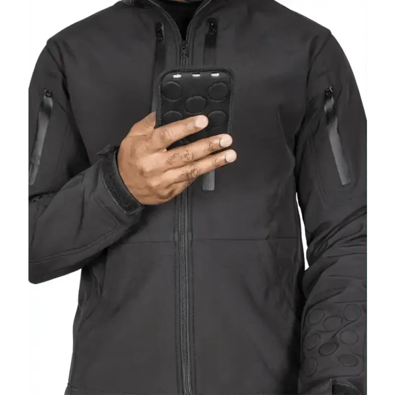 Hand holding a black smartphone in protective case by Tradecraft Tactical Jacket 2.0