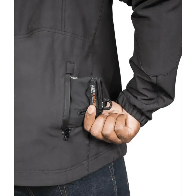 Hand accessing zippered pocket on Tradecraft Tactical Jacket for level IIIA body armor