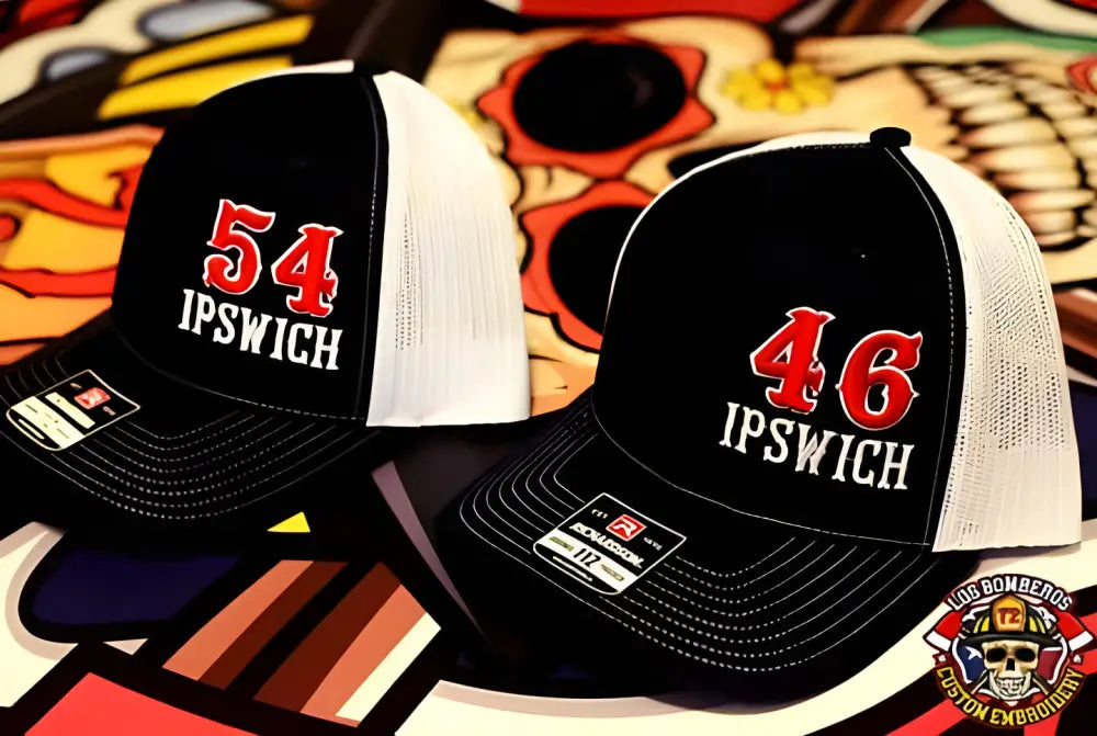 Two black and white mesh baseball caps with Ipswich and first responders numbers embroidered