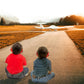 Two children watching a glider while wearing 23dB NRR noise cancelling hearing protection earmuffs