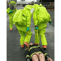 Two hazmat-suited figures using a Multi-Loop Rescue Strap in a critical examination