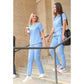 Two healthcare workers in light blue women’s stash-pocket scrub tops and white sneakers