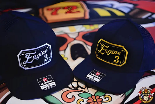 Two navy blue baseball caps with Engine 3 patches in square passport cursive design