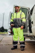 Worker in high-visibility gear by vehicle wearing UHV823 Hi-Vis Utility Rain Pants