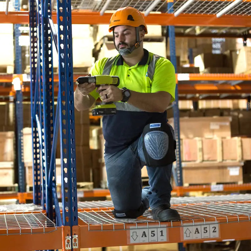 Warehouse worker using a drill while wearing a Rescue Hard Hat with ratchet suspension