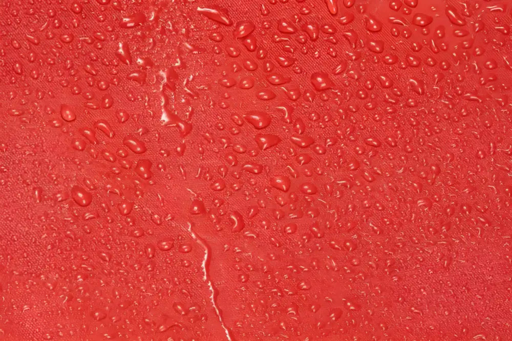 Water droplets on a red surface of the Line2Design Deluxe Step-In Firefighter Gear Bag