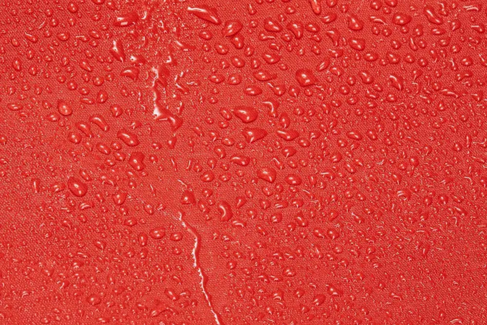 Water droplets on red surface of Firefighter Helmet and Turnout Gear Bag with Maltese Cross