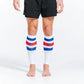 White calf sleeves with blue stripe and red accents worn on bare legs for support