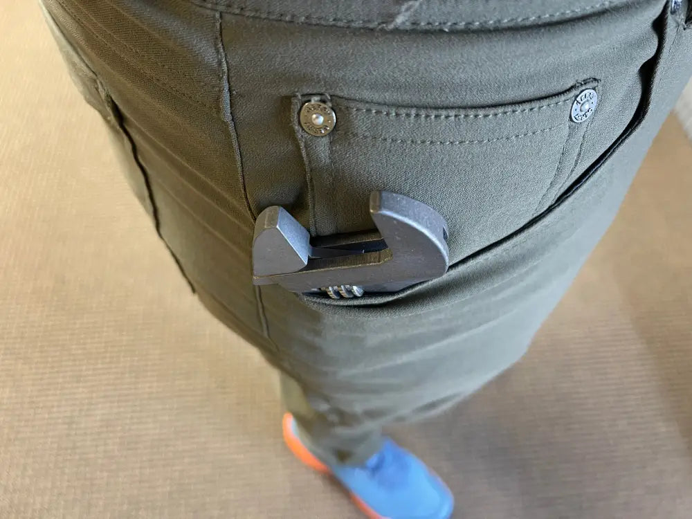 White earbuds in a green pants pocket with 8 Inch Titanium Adjustable Wrench nearby