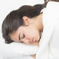 Sleeping woman wearing 32db NRR soft foam earplugs for peaceful rest