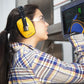 Woman in safety gear using a touchscreen with 23dB NRR noise cancelling hearing protection