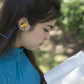 Woman reading while using Silicone Tri-Flange Corded Earplugs with flanged design