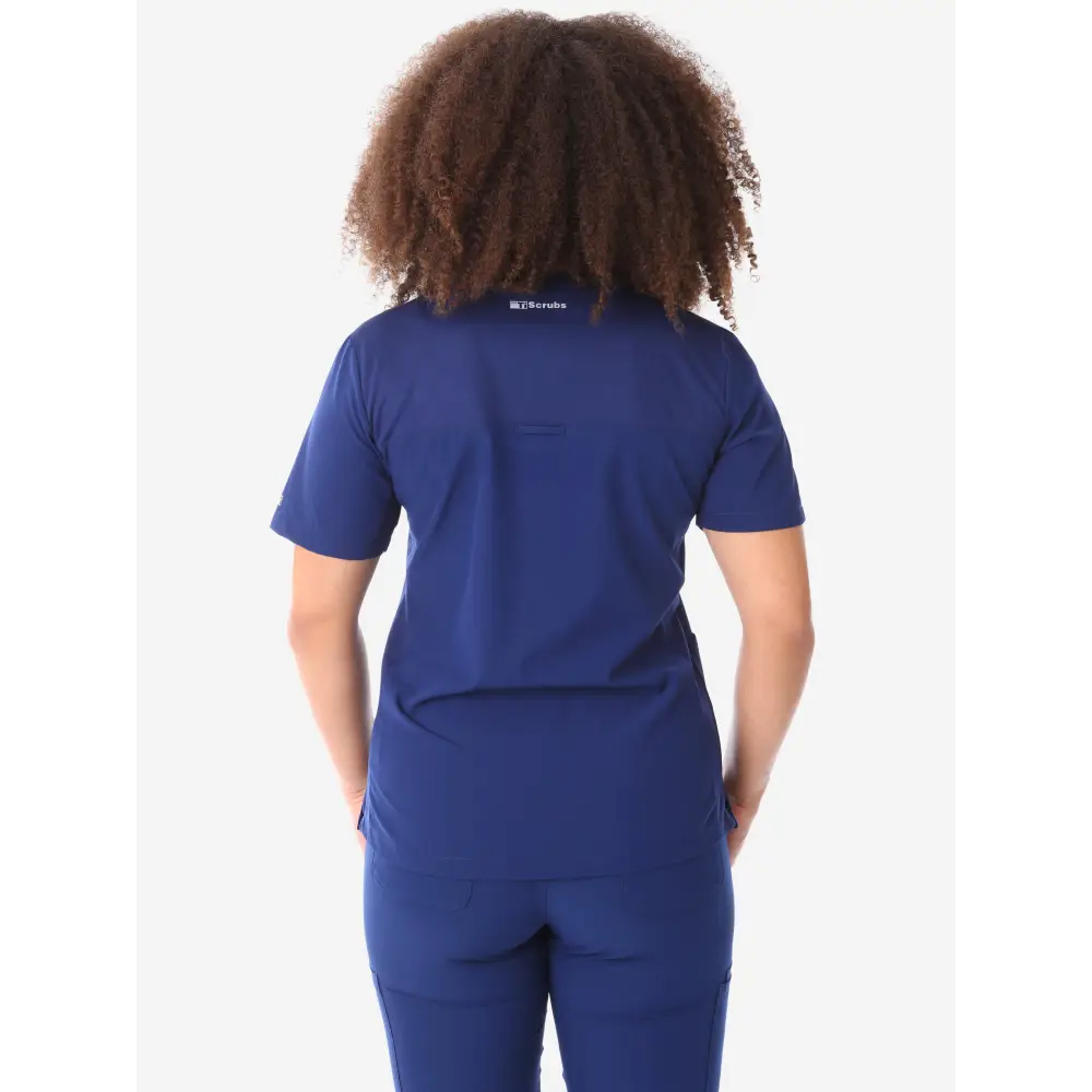 Back view of navy blue women’s four-pocket scrub uniform with visible curly hair