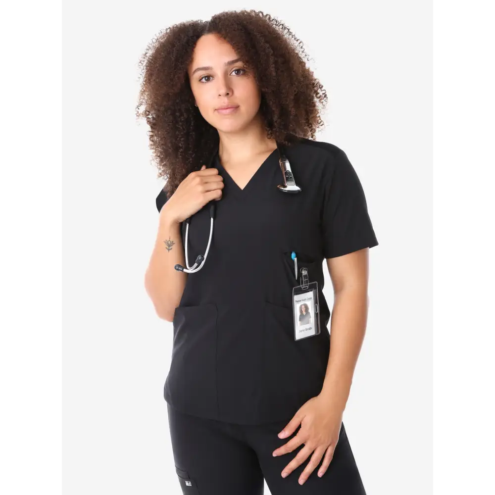 Healthcare worker in women’s four-pocket scrub top with stethoscope and ID badge