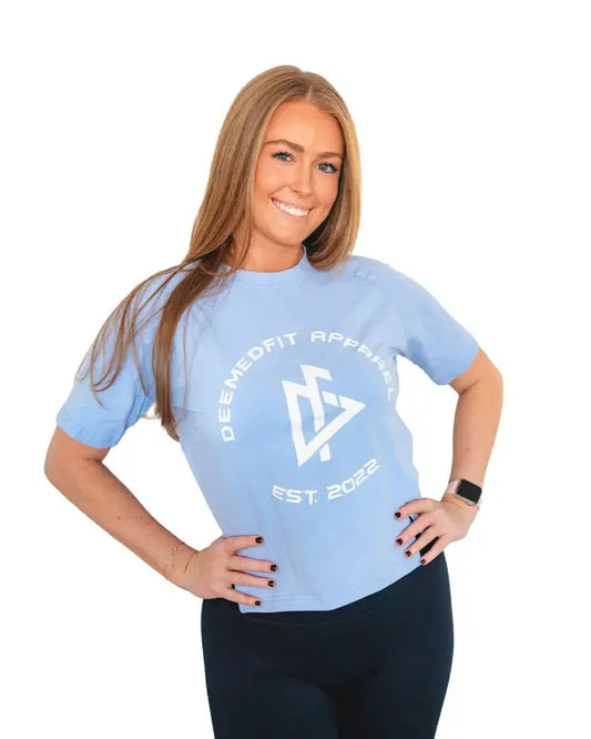 Light blue women’s performance tee Readiness with circular logo, model posing confidently