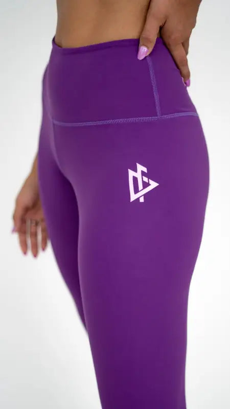 Purple women’s top-tier leggings featuring a white triangular logo on the thigh