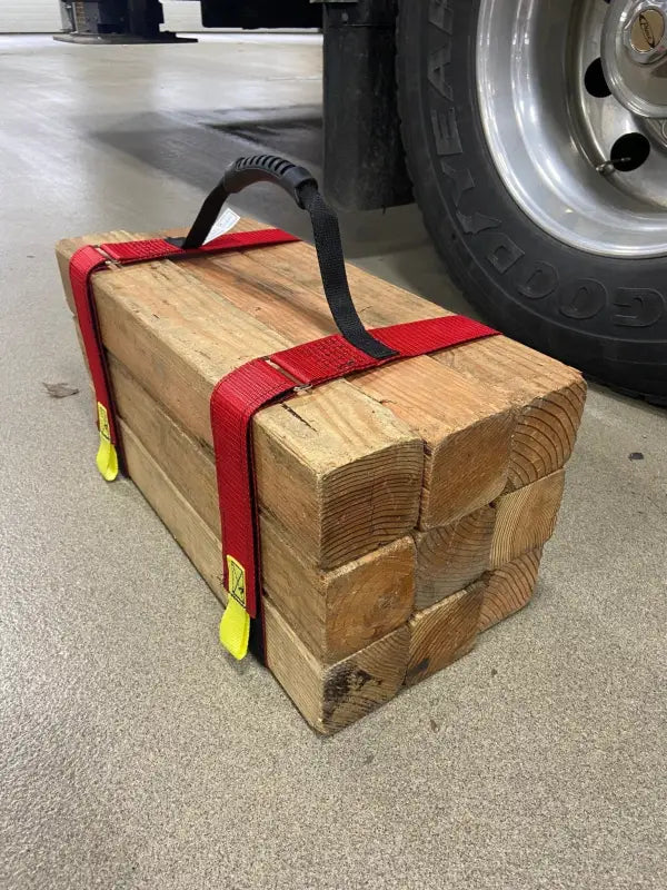 Wooden blocks held together with red straps and yellow hooks for Cribbing Strap Short