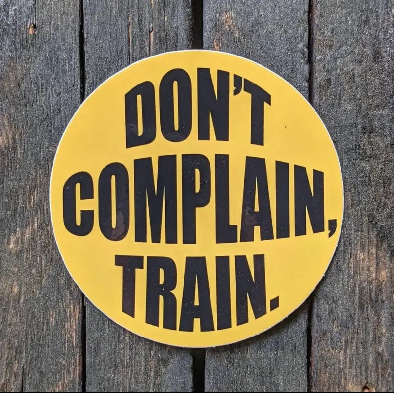 Yellow sign with black text Don’t Complain Train, perfect for firefighters and first responders