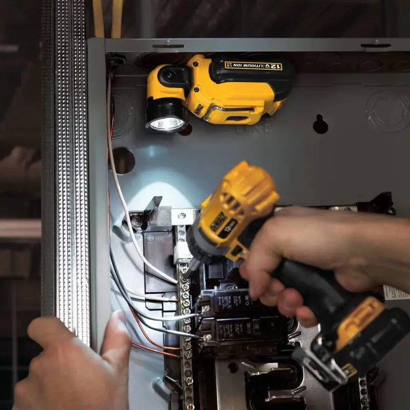 Yellow power drill used on electrical panel with DEWALT DCL510 12V MAX LED Work Light